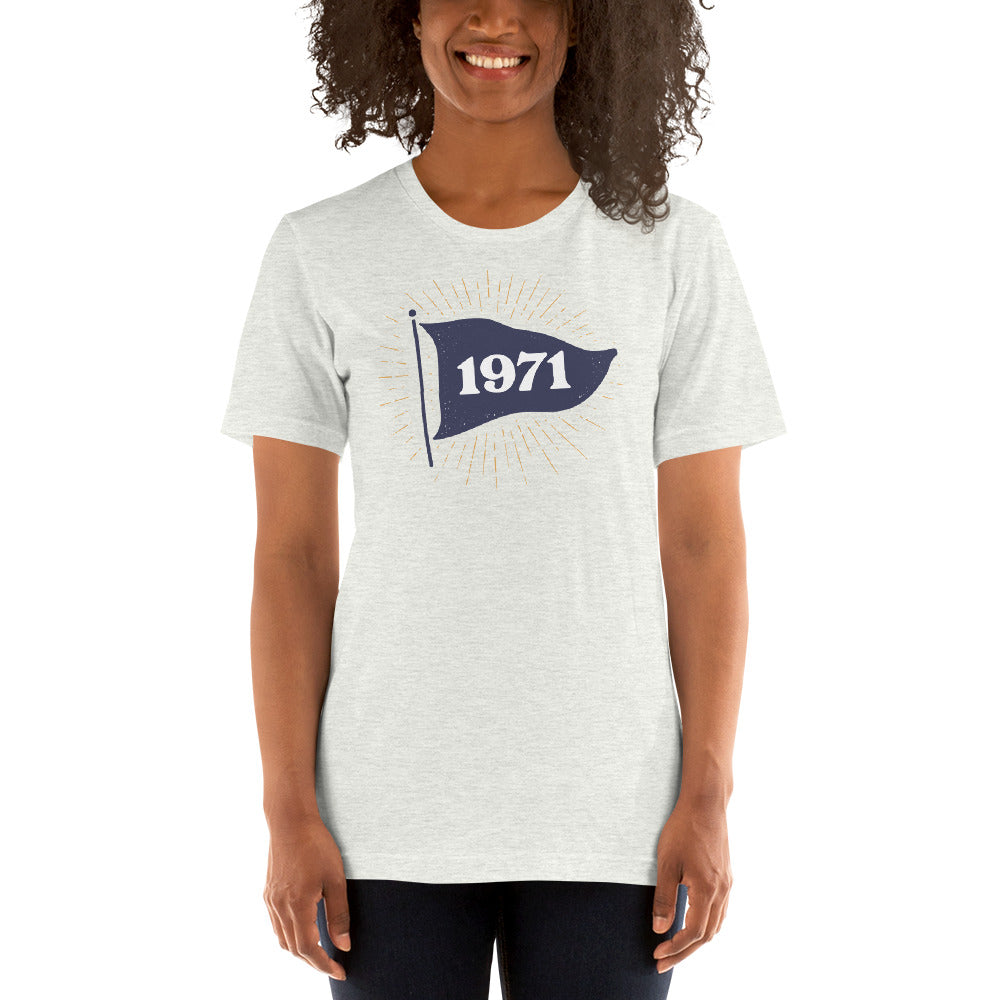 Woman wearing vintage style 1971 flag tee in the color ash. Navy flag with 1971 text in the middle of the flag.